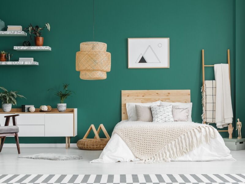 A bright bedroom with emerald green paint on the walls