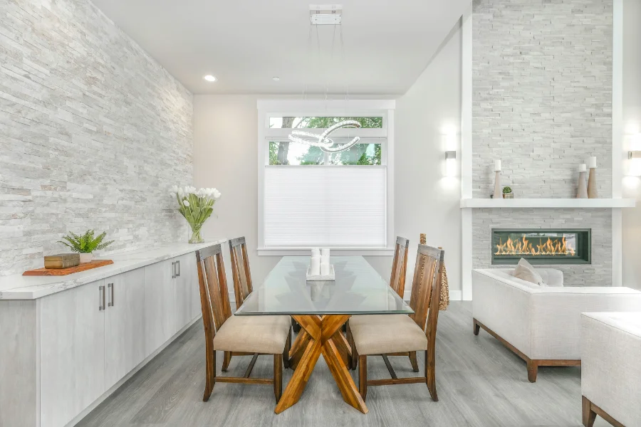 Simple diningroom off living space with greyscale brick wall finishing and wood furniture
