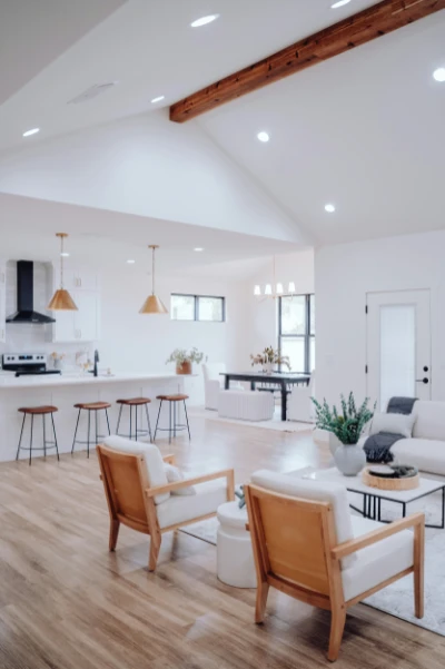 Bright white open living space with wooden beams and furniture with black accents and fixtures