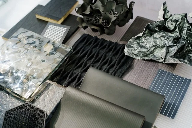 Various interior design swatches and fabrics featuring varied textures, all in the blue, grey, and black colour realm.