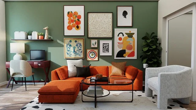An orange sofa sits in a room with a sage green feature wall that has several framed art pieces matching the colours of the couch.