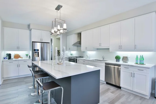 A bright, white kitchen featuring an island with seating.
